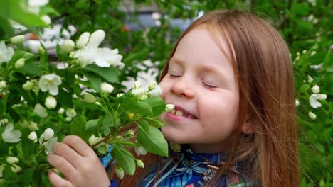 little girl sniffing flowers in springtime