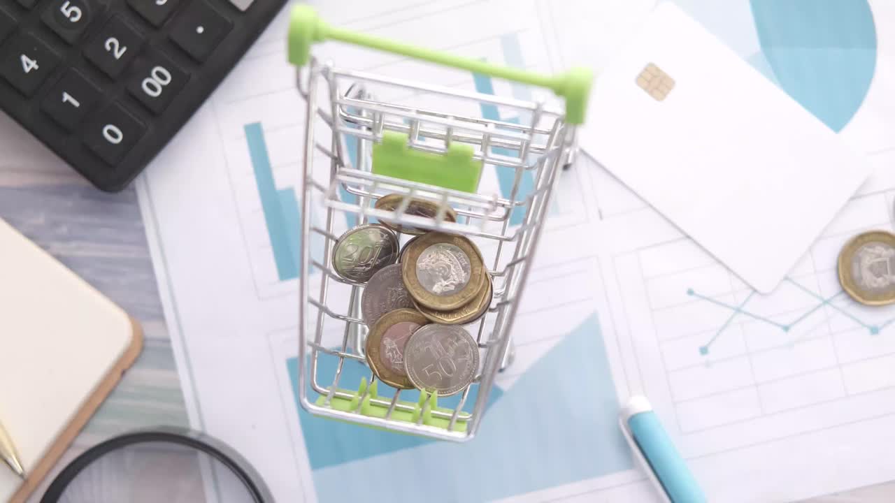 carrito de compras lleno de monedas en documentos financieros