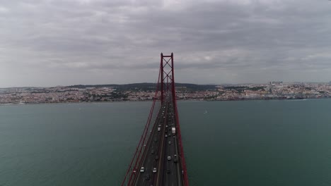 aerial close up view o cars driving on lisbon ponte 25 de abril suspension bridge at sunset, portugal