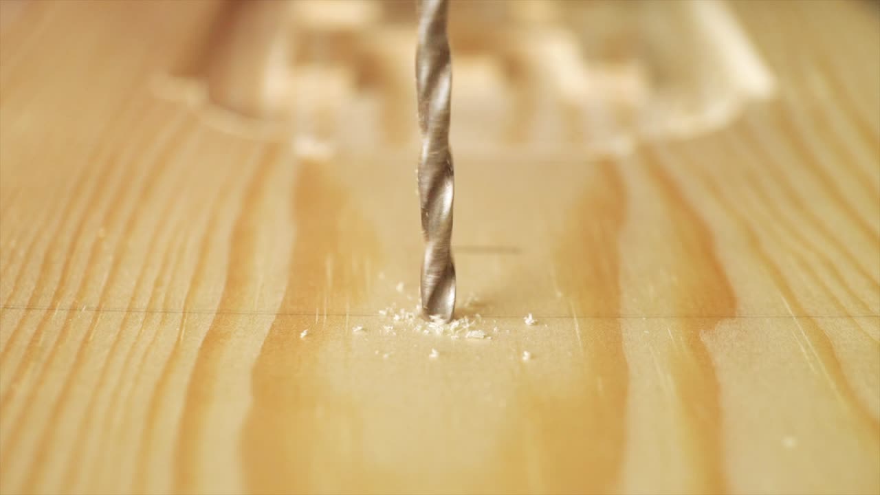 목재 조각을 드릴링하는 목수의 슬로우 모션 매크로 샷