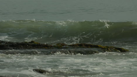 slow motion footage of a wave coming into shore along a pacific coast beach in southern california