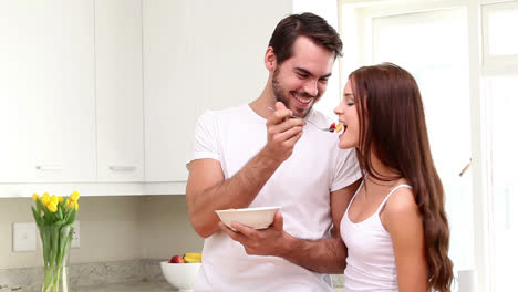 una pareja atractiva comiendo cereales por la mañana.