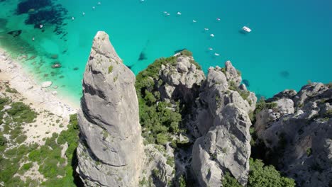 espectacular vista aérea de una costa rocosa con agua turquesa y barcos navegando cerca