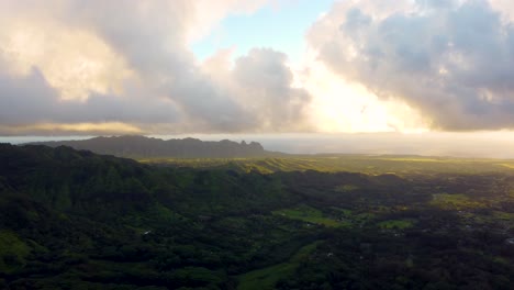 golden sunshine glowing on horizon at beautiful sunrise on kauai hawaii island under tropical rain clouds