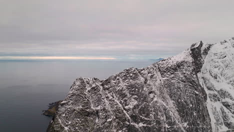 Sharp-snow-covered-mountain-peaks-of-Lofoten-islands,-Norway-aerial-view-flying-over-Nordic-landscape