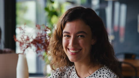 Retrato-De-Una-Joven-Empresaria-Sonriente-Sentada-En-Una-Cafetería