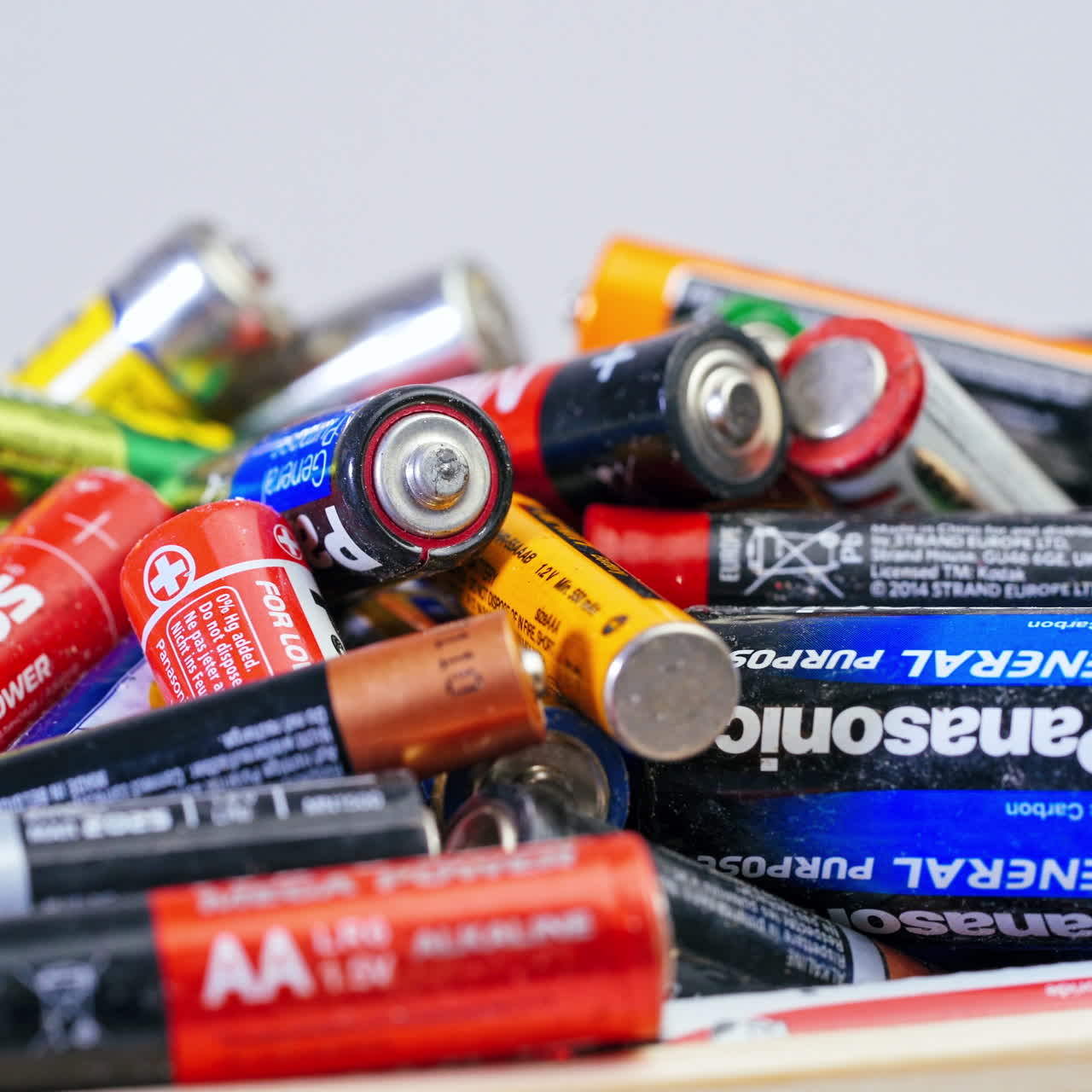 Used batteries preparing for recycling. Many used AA and AAA size batteries in a pile.