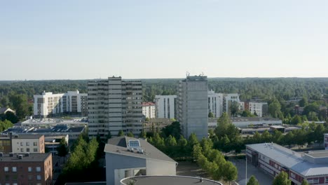 Umkehrende-Luftaufnahme-Von-Zwei-Großen-Türmen-Und-Einem-Runden-Gebäude-Darunter,-Finnland