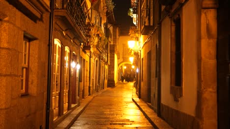 historic streets of guimarães at night on a rainy day with roman architecture and warm lighting