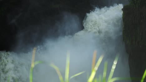 Nile-River-waterfall-tracking-Long-shot,-with-blades-of-grass-in-foreground