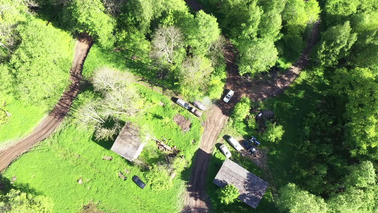 vehículos que salen a la pista de carreras forestales en la base rural, vista aérea de arriba hacia abajo