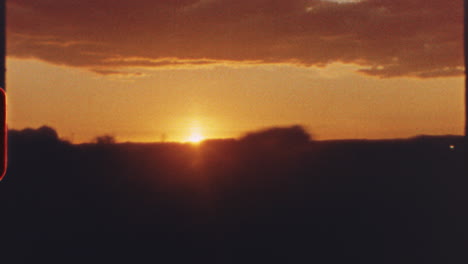 8 mm film - warm orange and red colors dominate the six separate shots of a setting sun, with silhouettes of landscapes and urban structures visible in the foreground