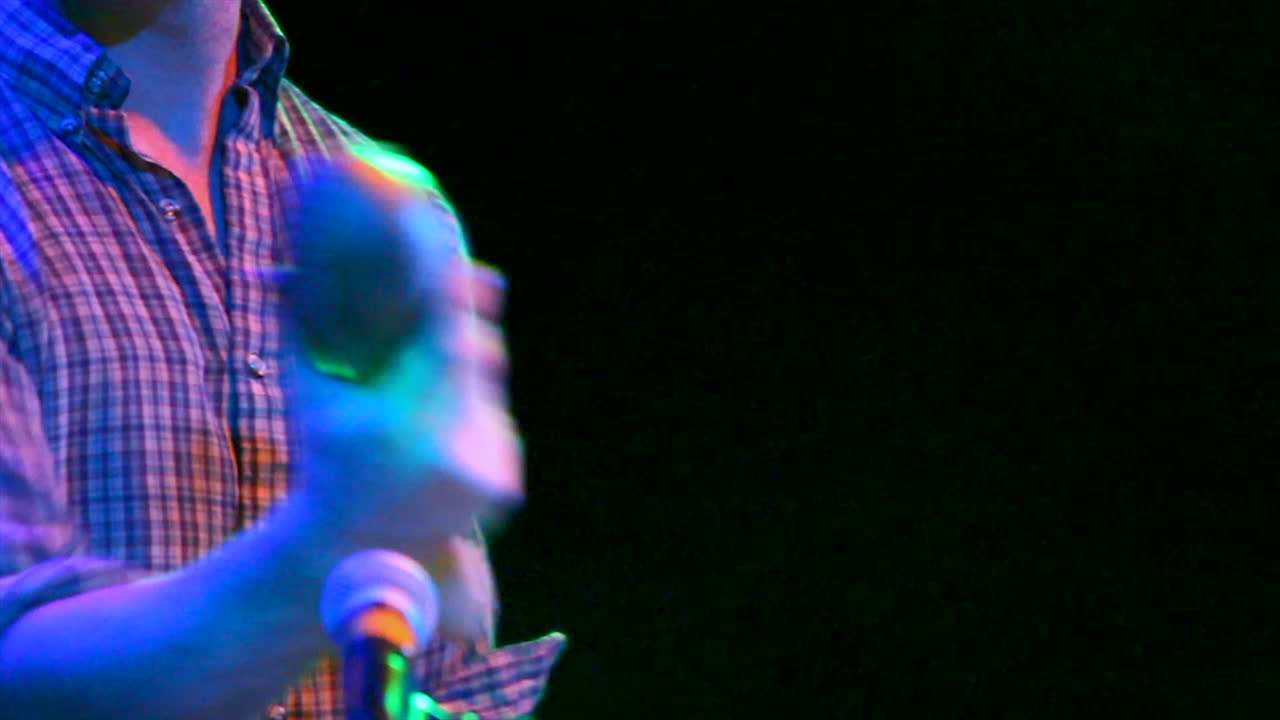 musicista che suona lo shaker sul palco al concerto