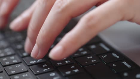 fotografía de cerca de las manos de una mujer de negocios escribiendo en el teclado de una computadora portátil para buscar información, soporte de comunicación en línea, investigación de mercadotecnia, informe de negocios en el escritorio de la oficina por la noche.