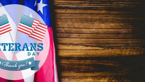 Composition-of-veterans-day-thank-you-text,-over-american-flag-and-wood