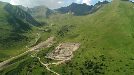 fotografía aérea de un sitio de construcción de una presa en las montañas alpinas