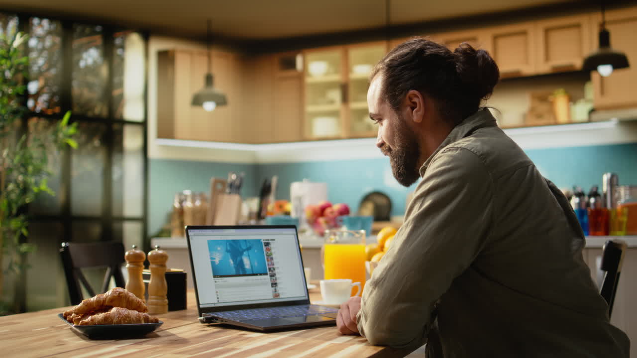Adult male browsing a video-sharing website using laptop