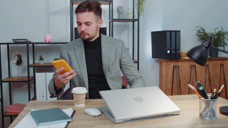 Businessman-in-suit-working-on-smartphone,-doing-manager-job,-typing-message-to-client,-office-room