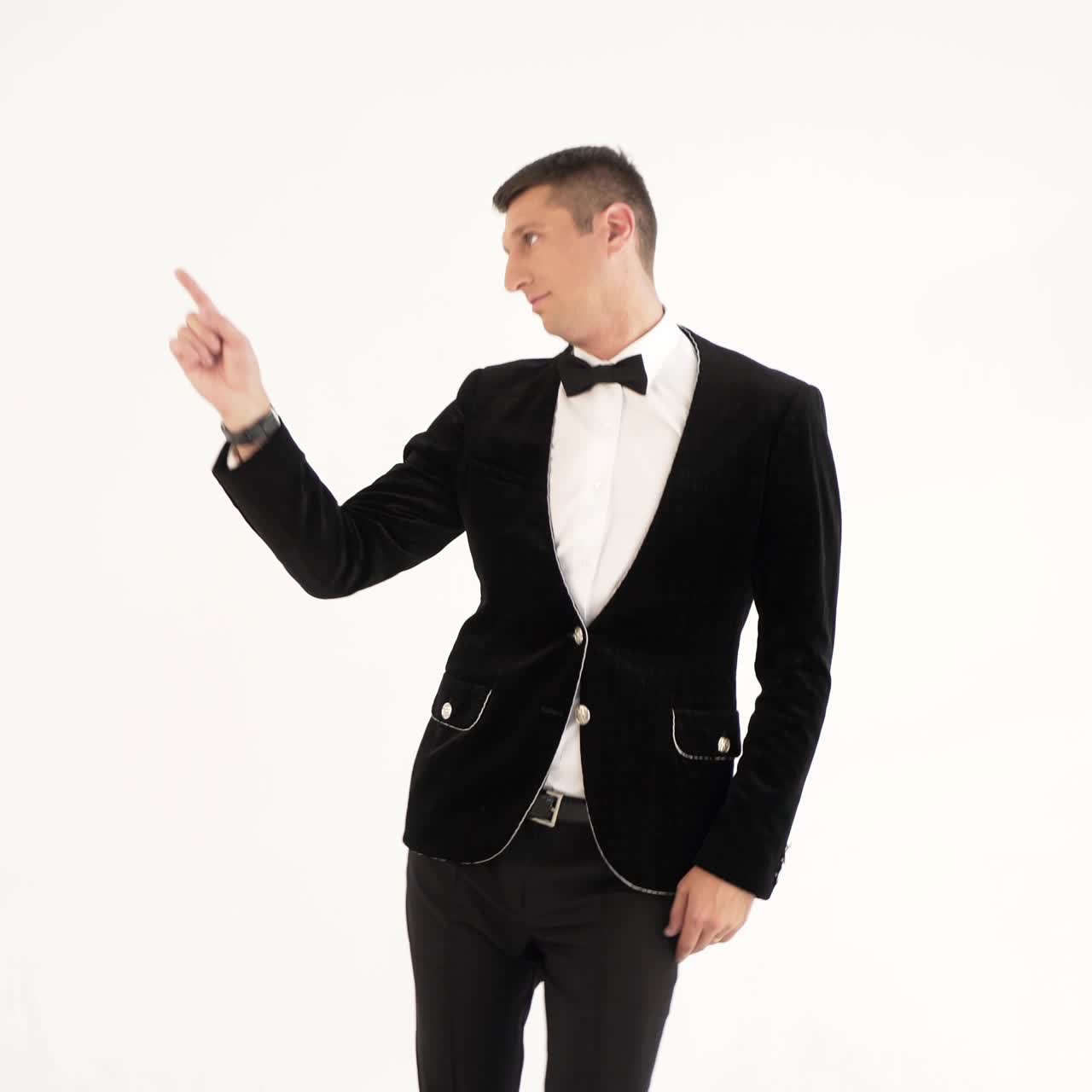 humorist in trendy costume is parodying a man who dancing in a club on a white background in the studio