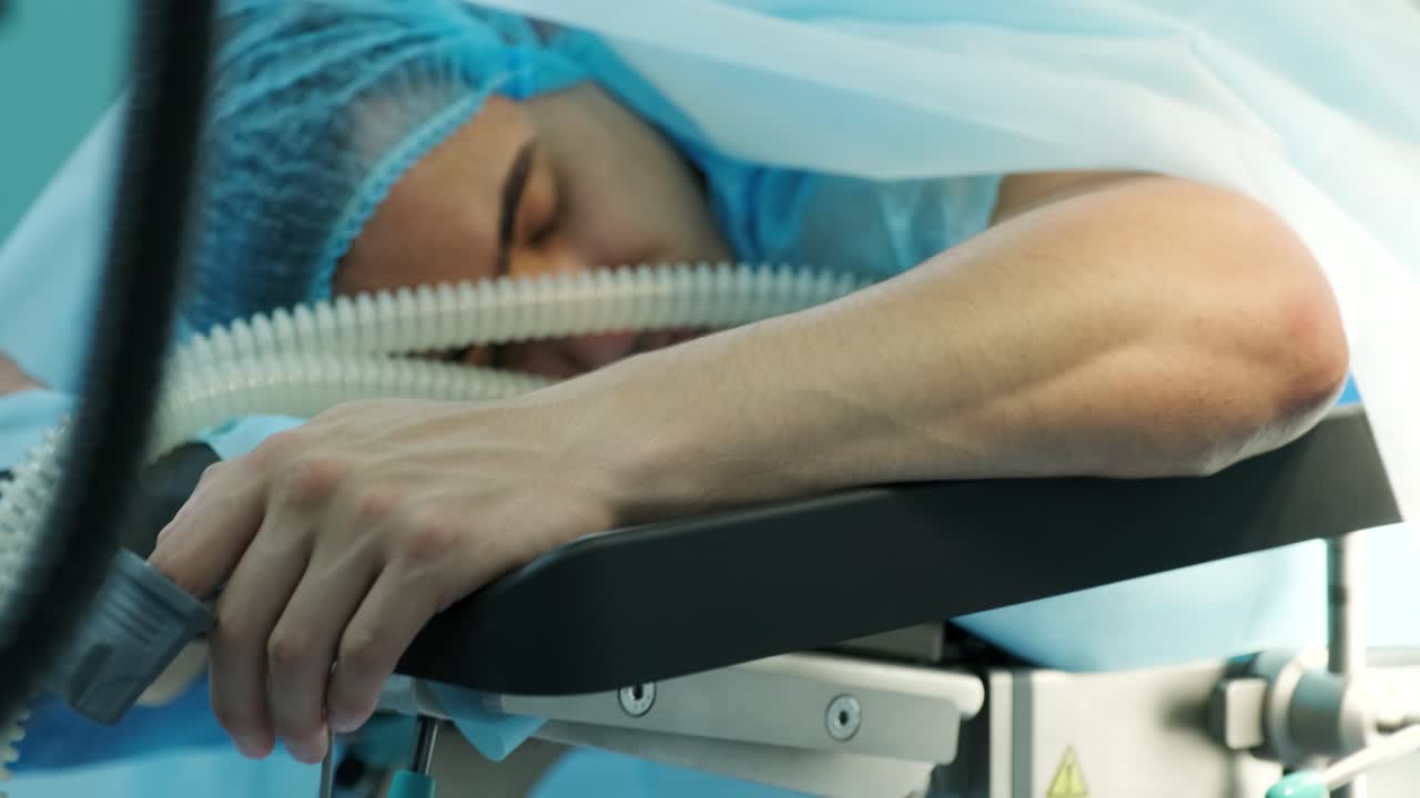 환자는 손가락에 센서를 달고 수술 테이블에 누워 있습니다.