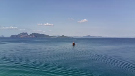 Fly-by-drone-shot-of-Thai-long-tail-boat-on-the-sea-in-front-of-Koh-Kradan-beach-in-Andaman-sea,-Trang,-Thailand