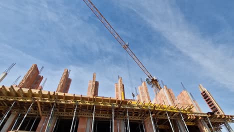 Yellow-crane-moving-and-transporting-heavy-load-at-construction-site-in-wide-angle-shot