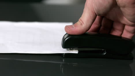 hand pushing down on stapler