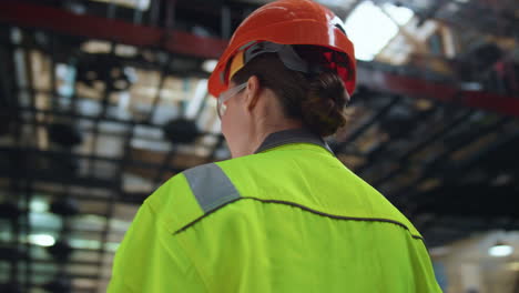 Joyful-woman-supervisor-smiling-at-huge-digital-modern-production-warehouse.