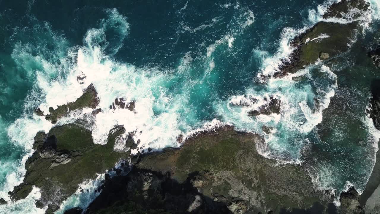 fotografía aérea de las olas del mar golpeando rocas y rocas en la playa en condiciones de sol - colina de pengilon, yogyakarta, indonesia, asia
