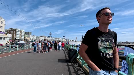 people walking on brighton pier under clear skies