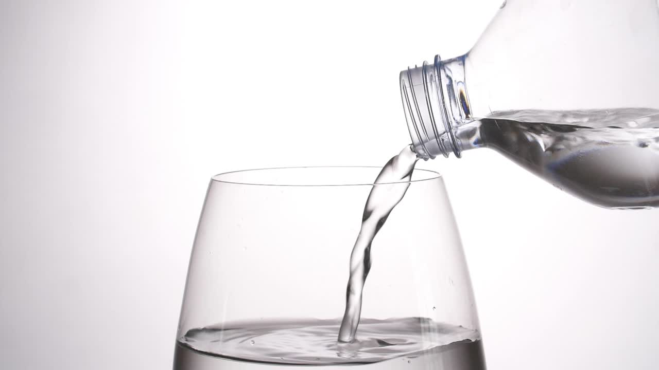 verter agua de una botella de plástico en un vaso