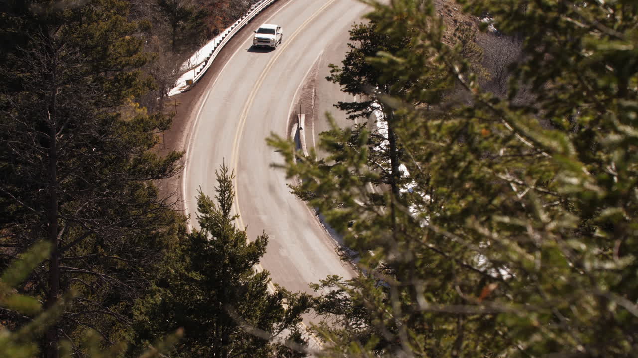 Un camion percorre una strada di montagna tortuosa nel bosco, teleobiettivo