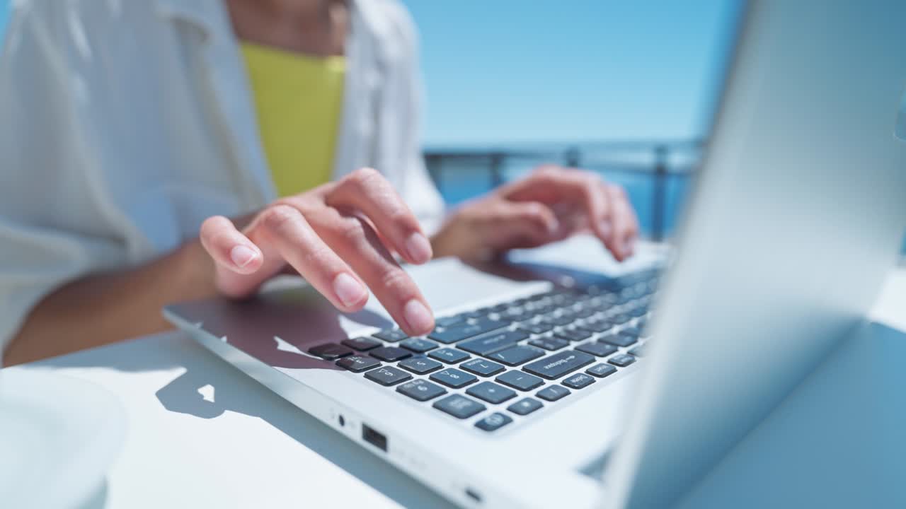 아름다운 바다 전망을 가진 야외 테라스에서 노트북 키보드에서 타이핑하는 여성. 가까이에서 컴퓨터에서 쓰는 여성 손. 여행, 프리랜서, 프로젝트, 글쓰기, 커뮤니케이션, 디지털, 학생 크리에이티브