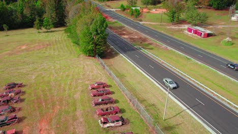 Aerial drone&#039;s bottom-up view over old cars buried in a field