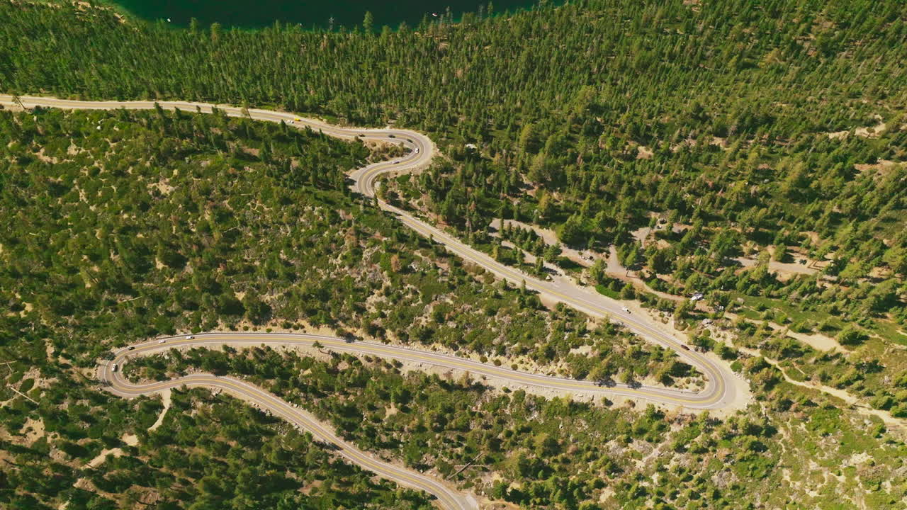 Mountain Road Winding Through Forest with Lake View