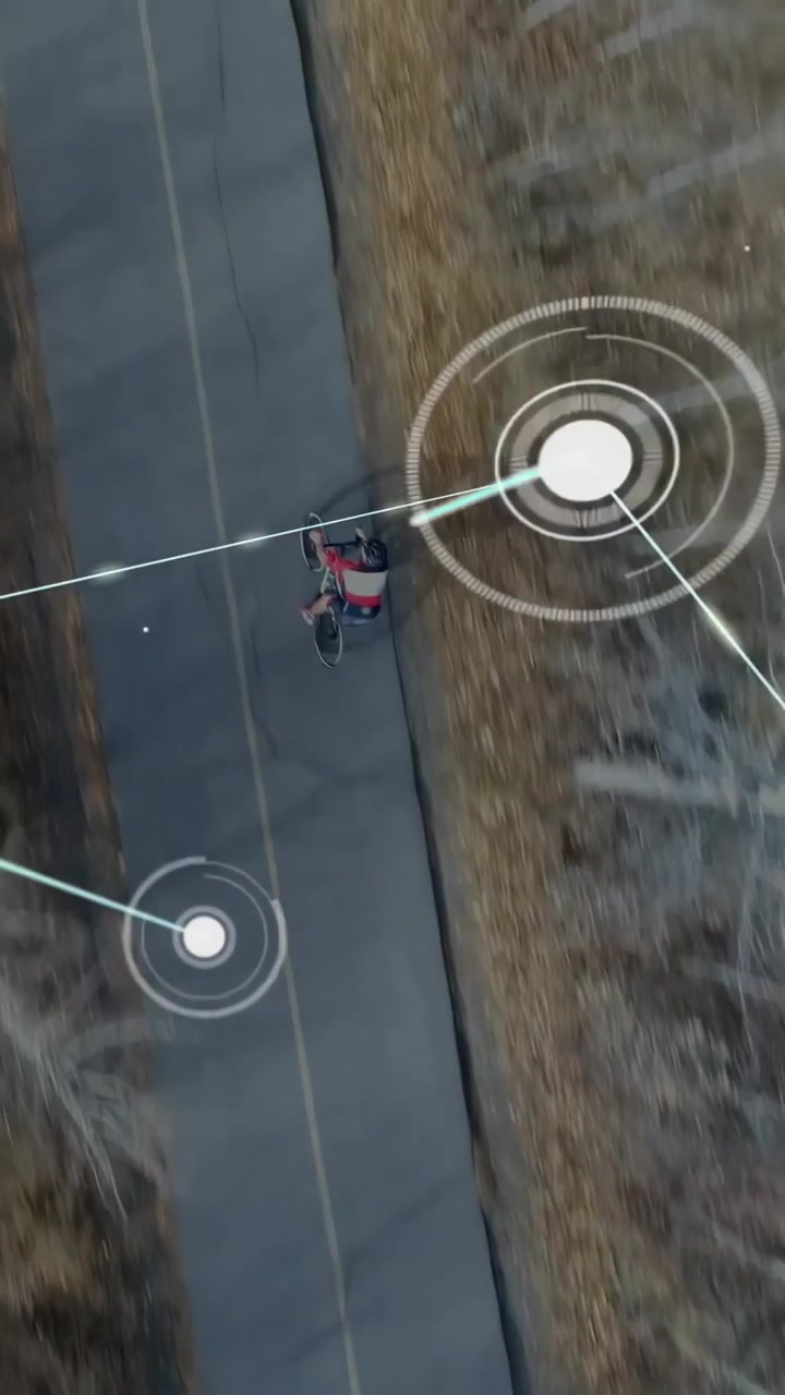 Vertical video: Teen male riding bike on rural road as AR HUD nodes expanding and obscuring rider