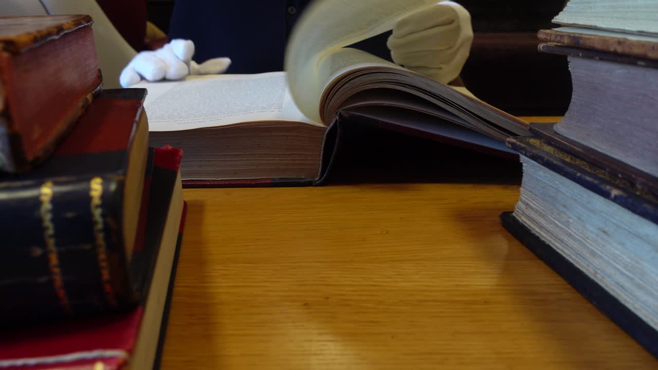 Man's hands leafing through an old book in the library
