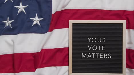 animated sign spelling out your vote matters lying on us stars and stripes flag for american election 2024 1