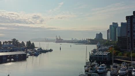 stunning drone aerial shot over the vancouver marina, moving closer to the cityscape skyscrapers canada