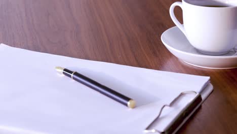 documents, pen and cup on table