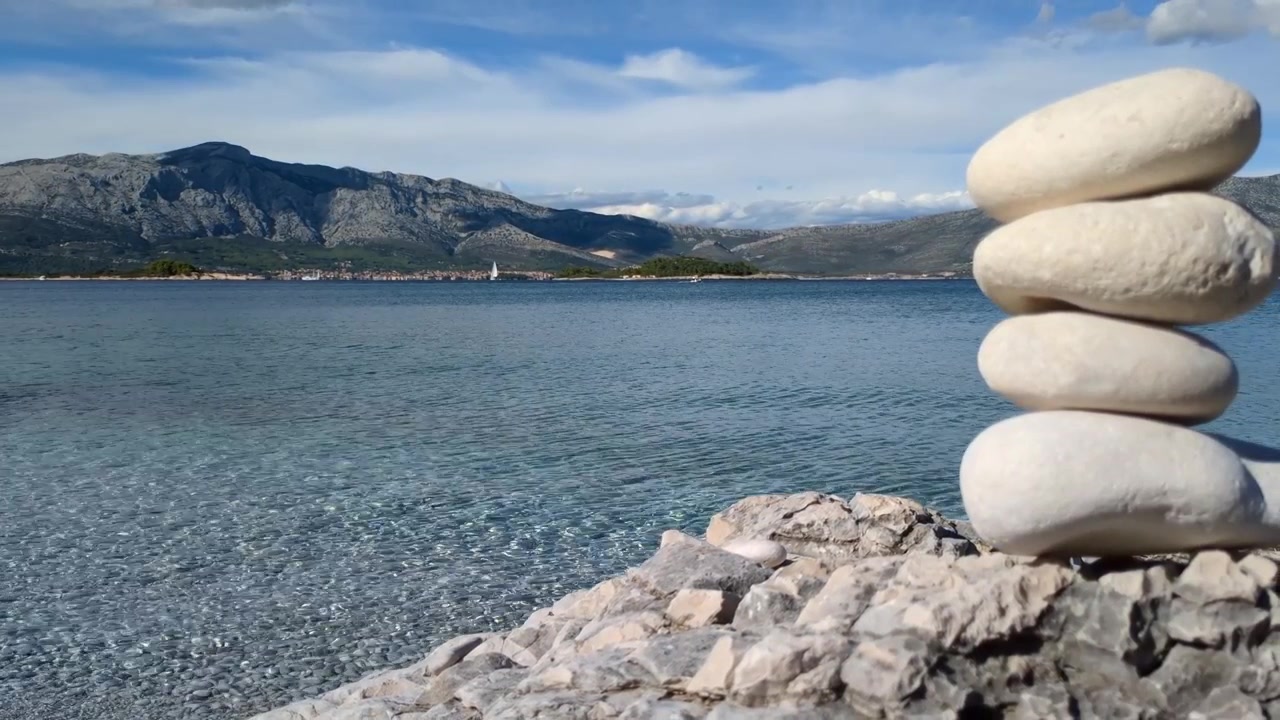 Pila di pietre in riva al mare con paesaggio sereno, equilibrio e armonia, serenità