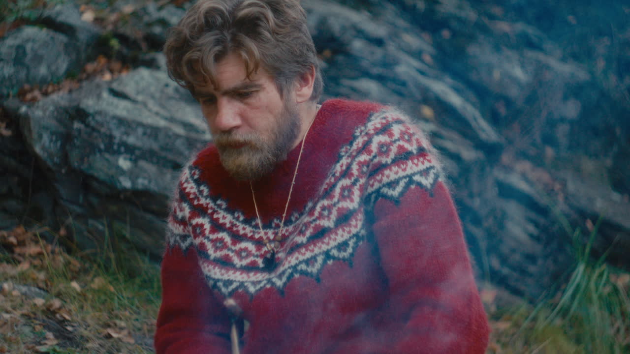 Man Eating Cooked Meat from Stick during Solo Survival Trip in Nature