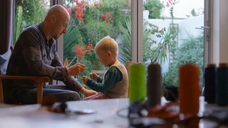 Padre-E-Hijo-Cosiendo-Llavero-En-Casa-4k