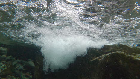 agua de río de montaña salvaje salpicando en el día de verano
