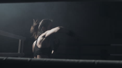 female boxer training in a dark, smoky ring