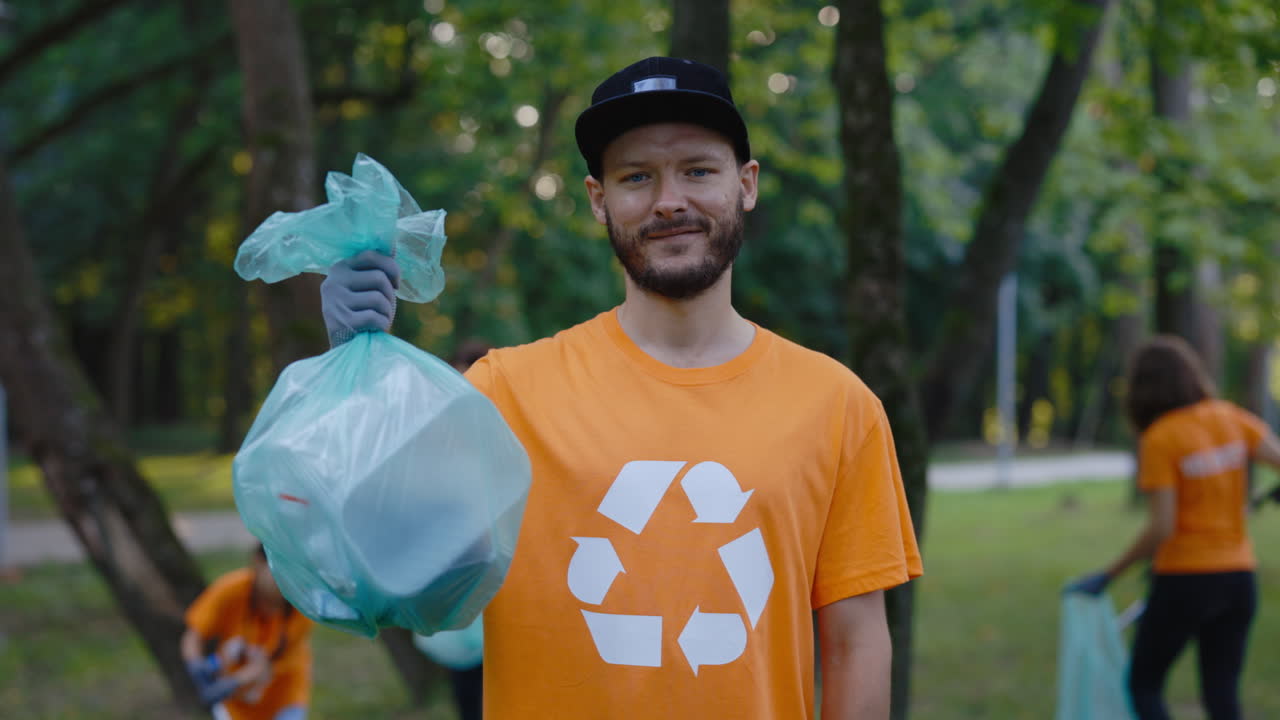 Man holding garbage bag in park