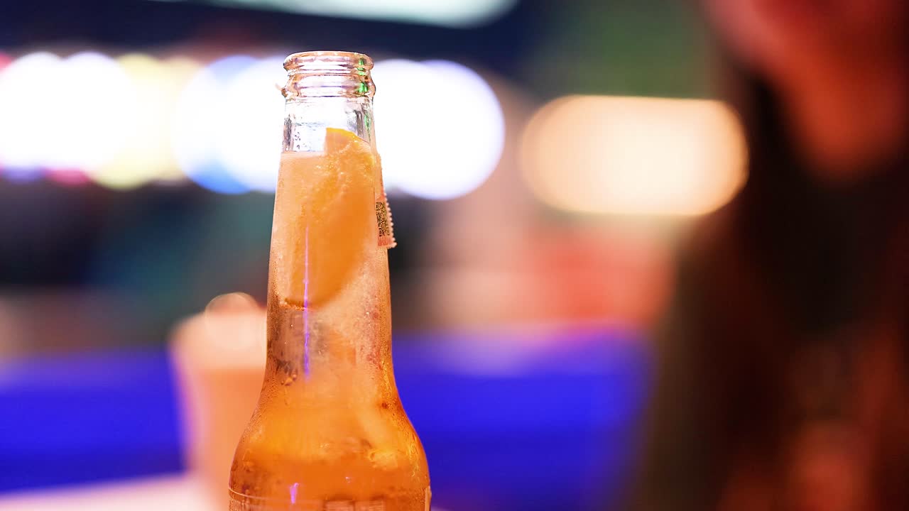 botella de cerveza con lima en un entorno vibrante
