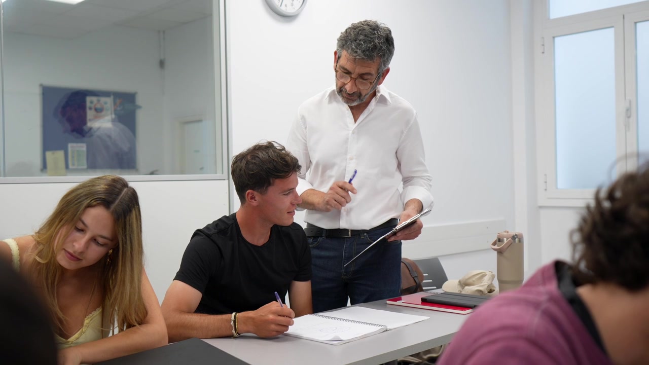 Professor auxiliando um aluno com seu trabalho em uma sala de aula moderna