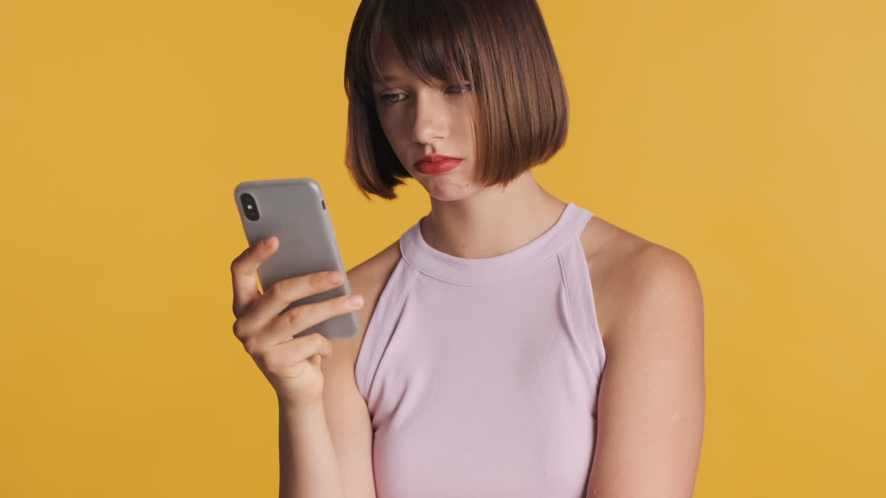 슬픈 여성이 스마트폰에서 슬픈 비디오를 보고 있습니다.