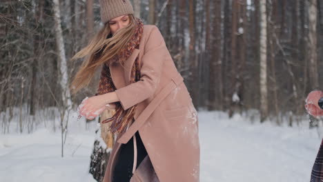 slow motion - couple snowball fighting in a field. they end their fight on a good terms with a high five.